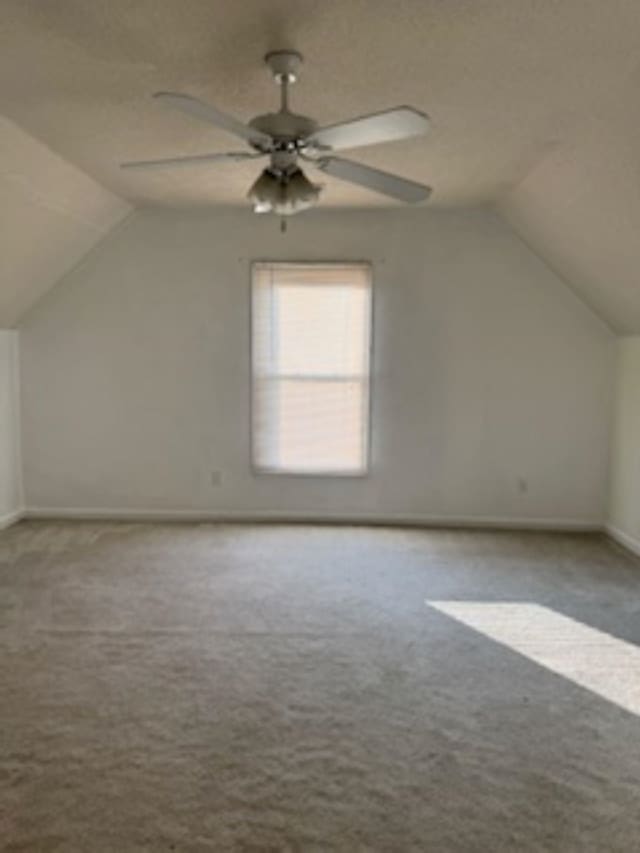 additional living space featuring lofted ceiling, ceiling fan, and light colored carpet