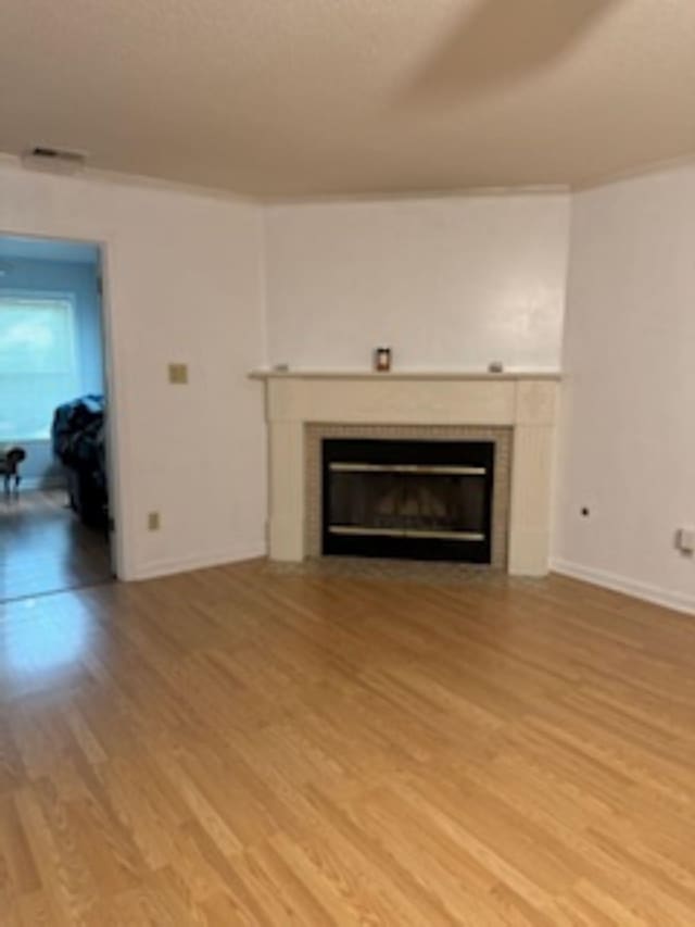 7565 Wintergreen Ln NW, Tn, TN 38018 - unfurnished living room with visible vents, baseboards, light wood finished floors, and a tile fireplace