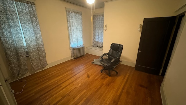 unfurnished room featuring radiator heating unit and hardwood / wood-style floors