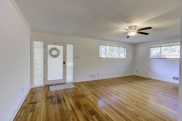 foyer entrance featuring a textured ceiling, ornamental molding, ceiling fan, and light hardwood / wood-style flooring