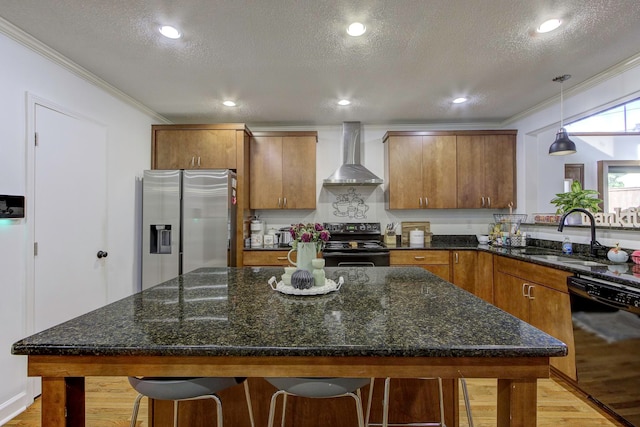 kitchen with wall chimney exhaust hood, pendant lighting, a textured ceiling, black appliances, and sink