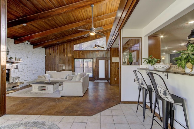 living room with french doors, wood walls, ceiling fan, and light tile patterned flooring