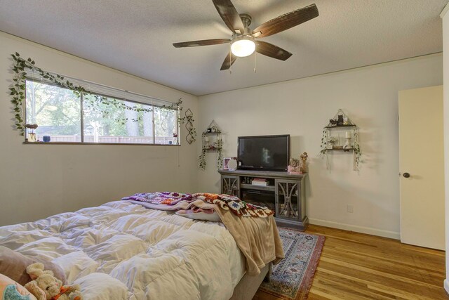 bedroom featuring ceiling fan, a textured ceiling, and wood-type flooring