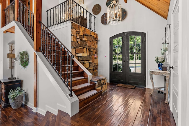 foyer entrance with wood ceiling, a chandelier, dark hardwood / wood-style floors, high vaulted ceiling, and french doors