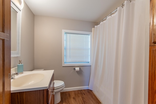 full bathroom with toilet, vanity, wood finished floors, and baseboards