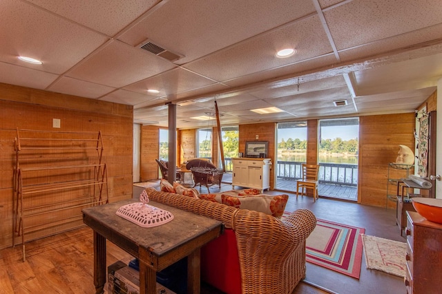 living room featuring visible vents, wood finished floors, and wood walls