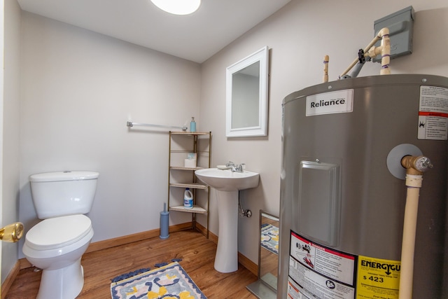 bathroom featuring water heater, toilet, and hardwood / wood-style flooring