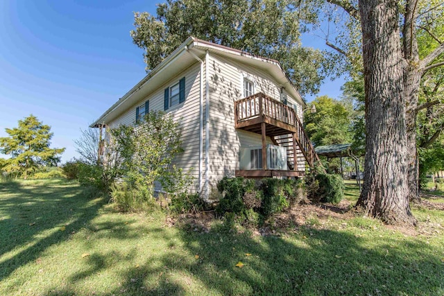 view of property exterior with a wooden deck, a lawn, and stairs