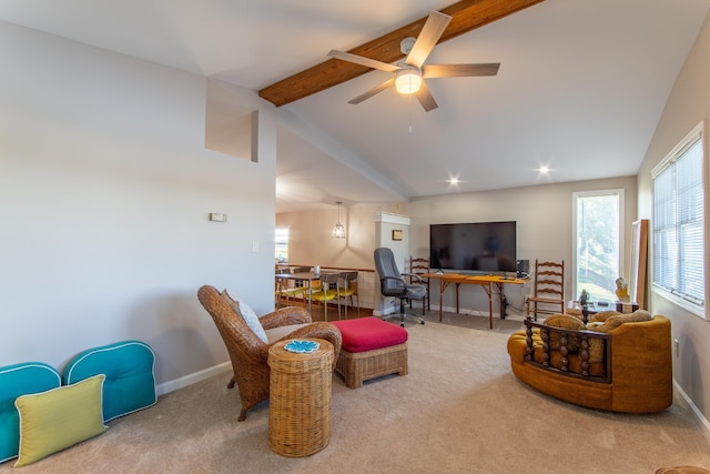 carpeted living area with vaulted ceiling with beams, baseboards, a ceiling fan, and a healthy amount of sunlight