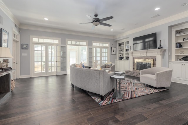 living room with ornamental molding, a brick fireplace, ceiling fan, and dark hardwood / wood-style floors