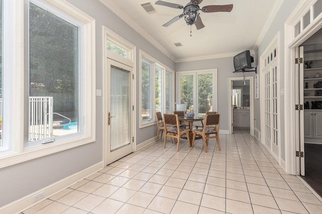 tiled dining room with ceiling fan and ornamental molding