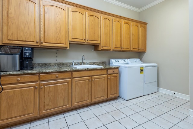 laundry area featuring cabinets, sink, washing machine and clothes dryer, light tile patterned floors, and crown molding