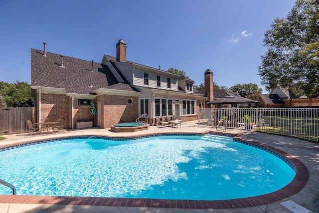 view of swimming pool featuring an in ground hot tub and a patio