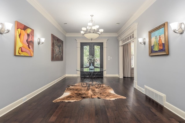 foyer featuring dark hardwood / wood-style floors, a chandelier, and crown molding