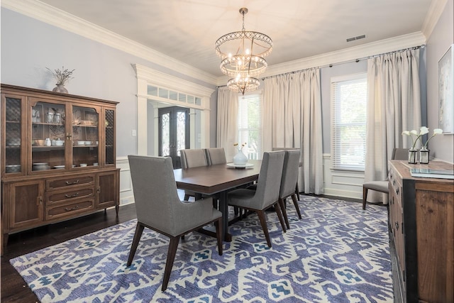 dining area featuring a notable chandelier, crown molding, and dark wood-type flooring