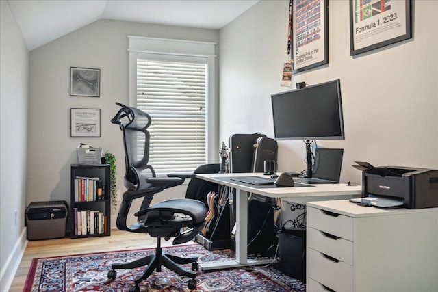 home office with light wood-type flooring and lofted ceiling