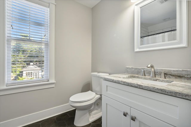 bathroom with tile patterned flooring, vanity, toilet, and baseboards