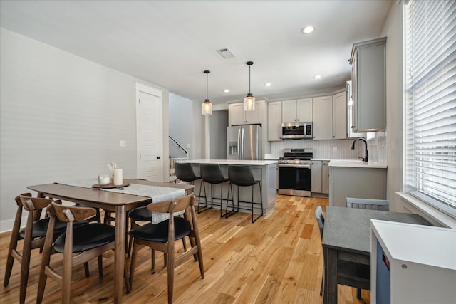 dining area with sink and light hardwood / wood-style floors