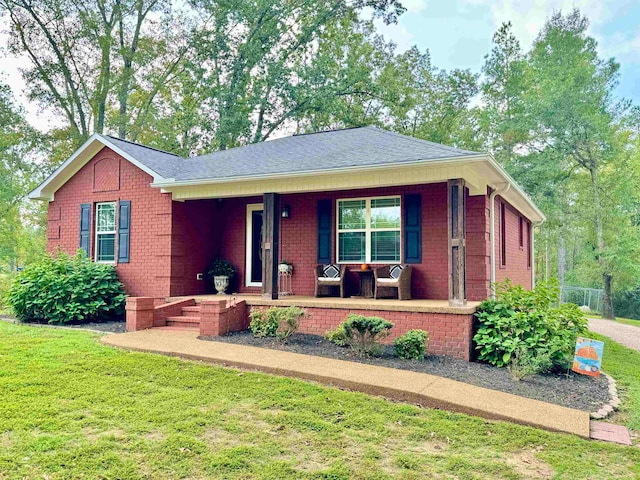 single story home with a porch and a front lawn