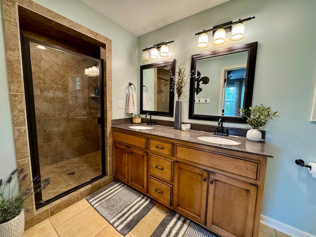 bathroom featuring tile patterned flooring, a textured ceiling, a shower with door, and vanity