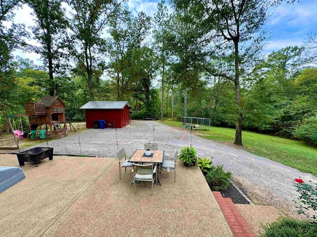 view of patio featuring a playground and an outbuilding