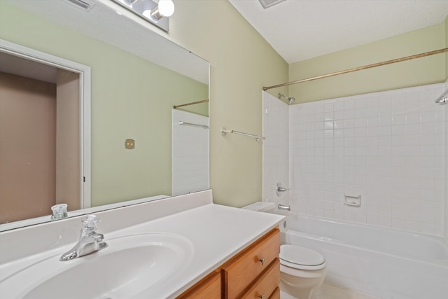 full bathroom with tiled shower / bath, vanity, toilet, and a textured ceiling