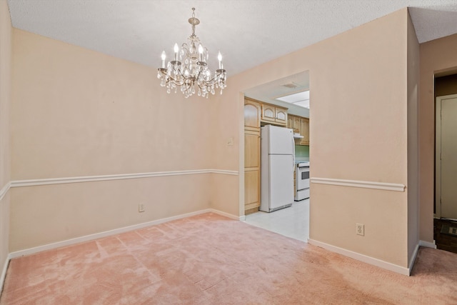 unfurnished dining area featuring light carpet, an inviting chandelier, and a textured ceiling