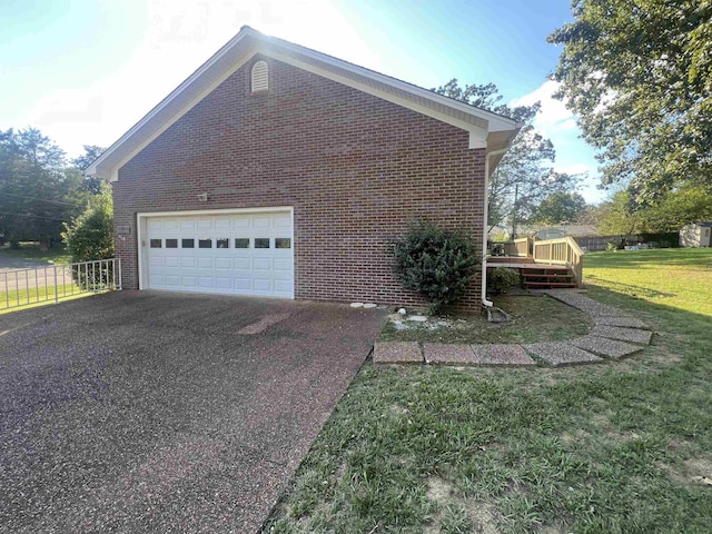 view of side of home with a deck, a garage, and a lawn