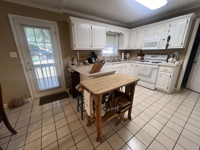 kitchen with crown molding, white cabinetry, light tile patterned floors, and white appliances