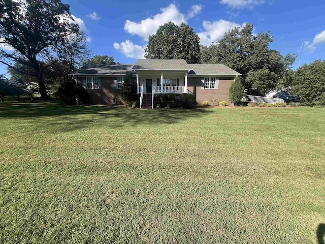 single story home with covered porch and a front yard