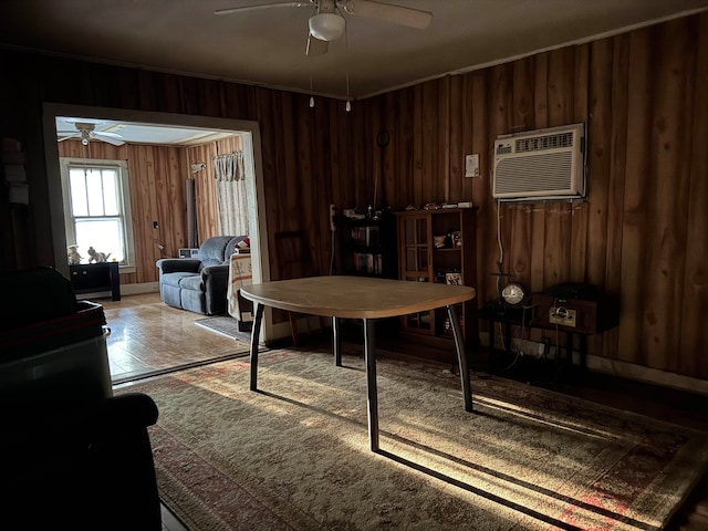 dining room with crown molding, wood walls, ceiling fan, and a wall mounted air conditioner