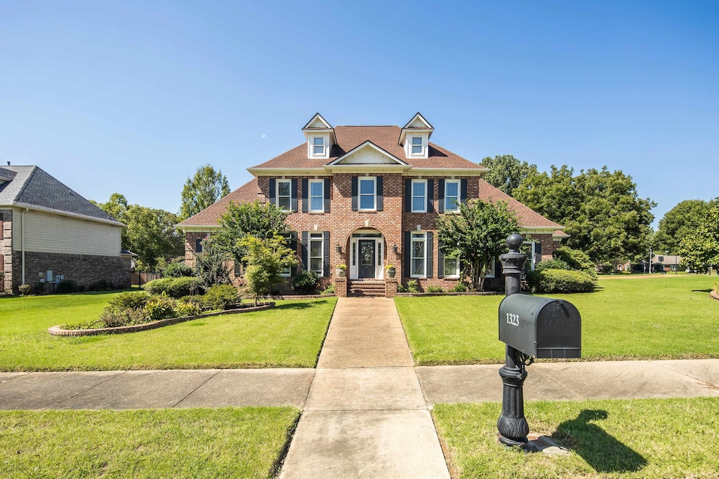 colonial-style house with a front lawn