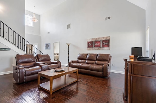 living room featuring an inviting chandelier, dark wood-type flooring, and high vaulted ceiling