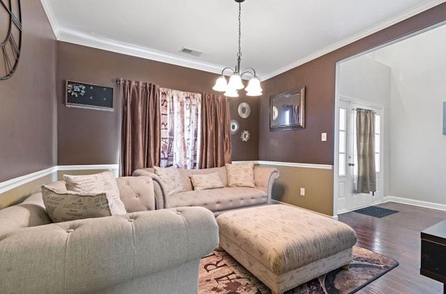 living room with an inviting chandelier, hardwood / wood-style floors, and crown molding