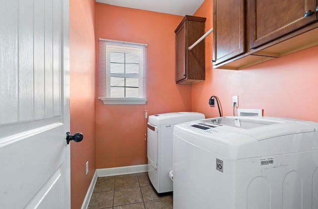 washroom with separate washer and dryer, cabinets, and tile patterned floors