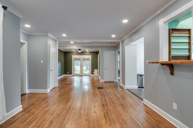 unfurnished living room featuring light hardwood / wood-style floors, french doors, and crown molding