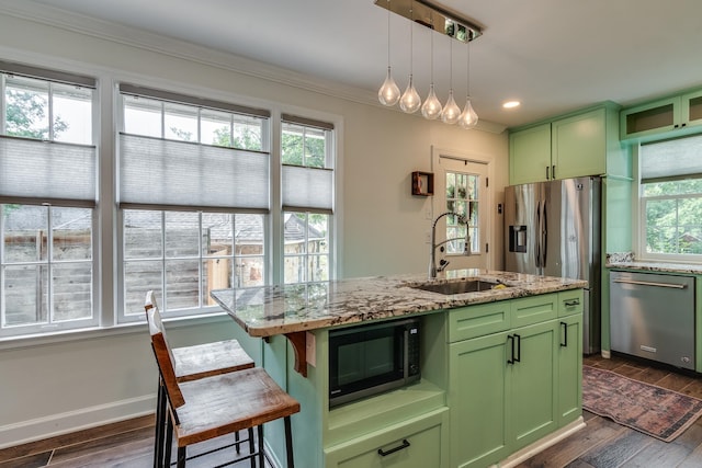 kitchen with sink, stainless steel dishwasher, green cabinetry, a center island with sink, and light stone countertops