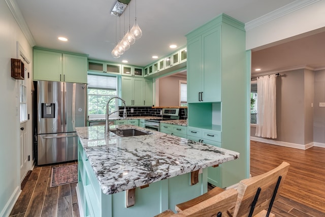 kitchen featuring appliances with stainless steel finishes, sink, dark wood-type flooring, and a wealth of natural light