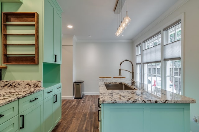 kitchen with pendant lighting, a kitchen island with sink, dark hardwood / wood-style floors, and sink