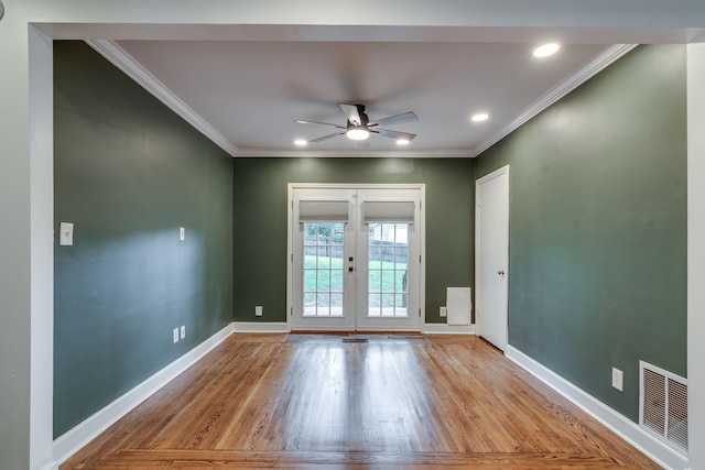 unfurnished room with ornamental molding, light wood-type flooring, ceiling fan, and french doors