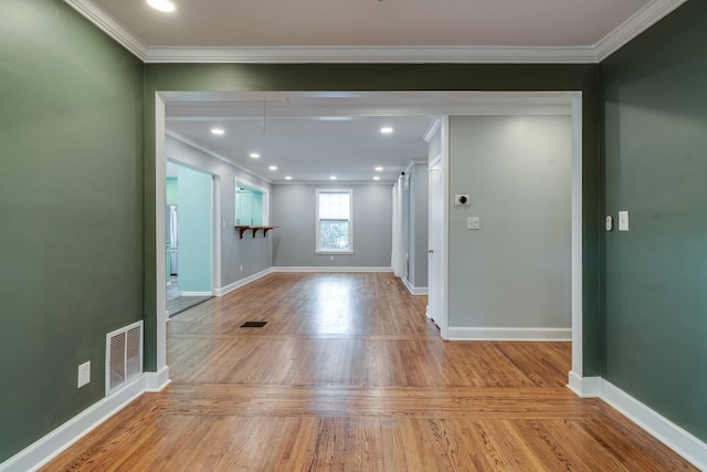 foyer with light hardwood / wood-style floors and crown molding