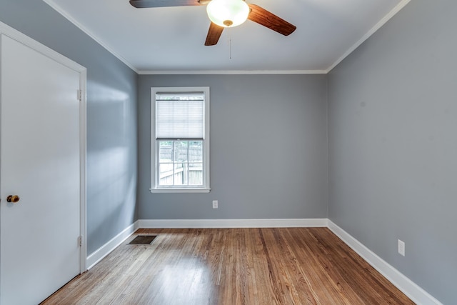 unfurnished room with ceiling fan, crown molding, and wood-type flooring