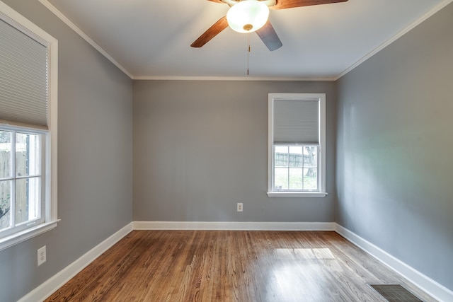 spare room with hardwood / wood-style flooring, crown molding, ceiling fan, and plenty of natural light