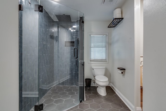 bathroom with tile patterned flooring, toilet, and an enclosed shower