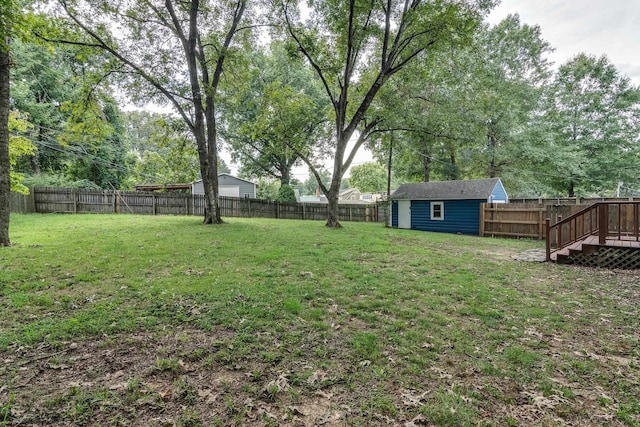 view of yard with a wooden deck and a storage shed