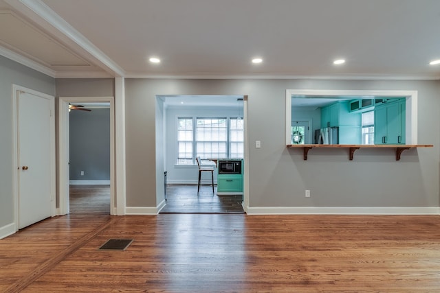 unfurnished room featuring ceiling fan, dark hardwood / wood-style floors, and crown molding