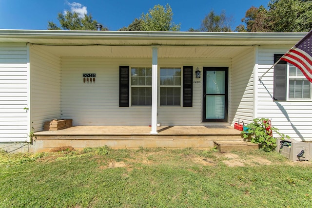 entrance to property featuring a yard and a porch