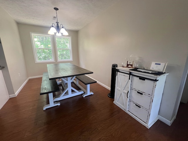 dining space featuring a textured ceiling, dark hardwood / wood-style floors, and a notable chandelier