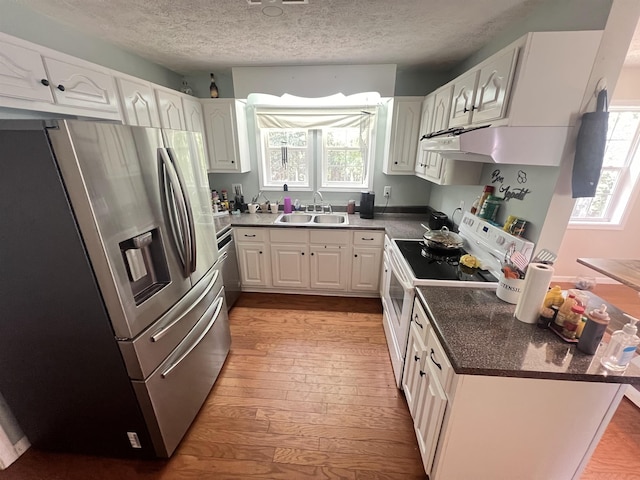 kitchen with light hardwood / wood-style floors, white cabinetry, stainless steel appliances, a textured ceiling, and sink