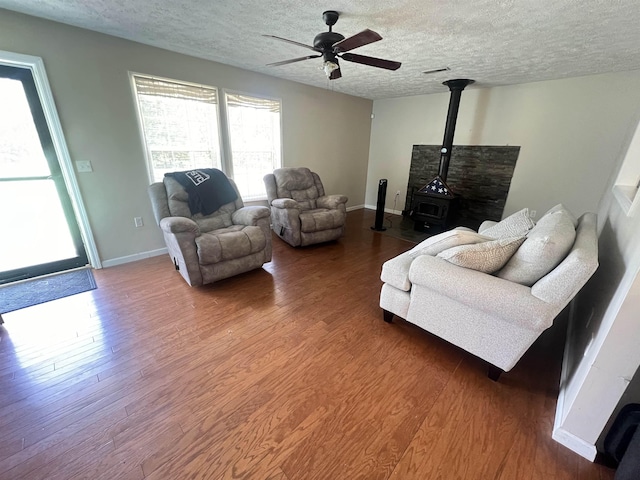 1405 Hurricane Dr, Sardis, TN 38371 - living area with a ceiling fan, a textured ceiling, wood finished floors, and a wood stove